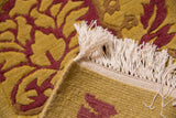 Embossed raspberry and saffron Damask floral pattern with antique ivory fringe.