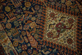 Navy and ivory fields featuring bird, plant, and pinwheel motifs on the Indian Shiraz rug.