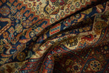 Draped pile of vintage Indian Shiraz rug featuring navy blue, chestnut, and gold motifs.