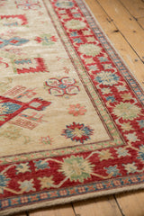 Pakistani Kazak rug corner with intact ivory fringe and red, blue, green floral border.