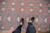Close view of the raised floral pile in cochineal red and ivory on a silver flatweave rug.