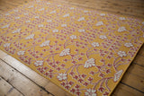 Raised ivory floral motifs on the saffron yellow flatweave of a modern Samarkand design carpet.