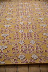 Raised Soumac weave of ivory and red floral petals on a saffron yellow flatweave rug.
