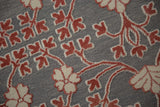 Raised cochineal red and ivory floral pile contrasted against the silver flatweave background.