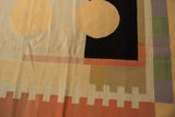 Contemporary Kilim rug detail featuring ivory circle, black rectangle, and colorful banded patterns.