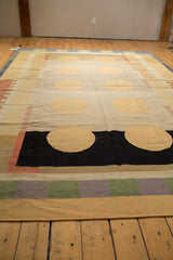 Hand woven contemporary Kilim rug with ivory, black, and blush circles on banded sections.