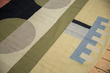 Abstract shapes and flat-woven texture on the contemporary kilim in olive, black, and light blue.