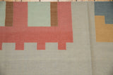 Abstract geometric pattern detail of Contemporary Kilim rug in raspberry, beige, and powder blue.