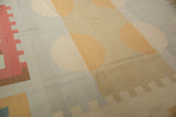 Abstract geometric pattern of beige circles and a stepped raspberry red border on a vintage kilim.