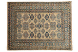 Pakistani Kazak design rug with repeating blue and sand geometric medallions on an antique ivory field.