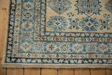 Corner of a Pakistani Kazak rug with geometric borders in sapphire blue, sky blue, and ivory.