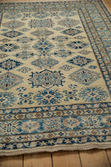 Low angle view of the plush, full pile on a new Kazak rug with geometric blue medallions.