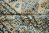 Stepped medallions and hook motifs in sapphire blue and sand on the plush, full pile of a Kazak design rug.
