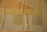 Flat-woven texture showing modern Argyle-inspired pattern with alternating copper, gold, and beige tones.