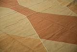 Hand woven kilim featuring geometric diamond pattern in copper and sand tones.