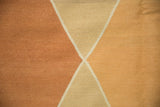 Modern Argyle diamond pattern close-up, hand-woven kilim in pale copper, gold, and ivory.