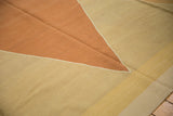 Detail of handwoven kilim's angular dusty terracotta and sand pattern.