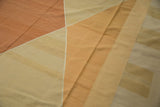 Geometric diamond pattern and soft abrashes on a modern Kilim rug in copper and beige.
