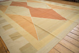 Modern geometric design on a hand-woven Kilim carpet with copper and sand tones.