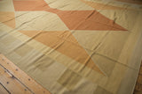 Modern Indian kilim carpet with Argyle diamond pattern in varied beige, sand, and copper hues.