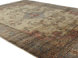 Corner of a vintage Romanian Tabriz design carpet, dusty rose and blue floral motifs.