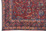 Detailed corner of a vintage Laristan carpet with indigo and blush floral palmettes.