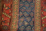 Distinct wide main border and intricate navy boteh patterns of an antique Kurdish rug.