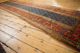 Detail of antique Kurdish runner: wide border with geometric motifs, navy boteh field, and terra cotta accents.