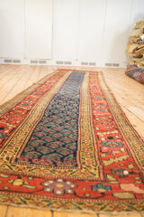 Nuanced wide terra cotta main border and repeating navy boteh motif on antique Kurdish runner.