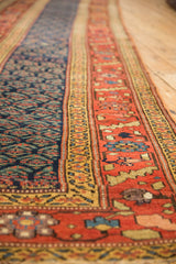 Detail of antique Kurdish runner, navy field's staggered boteh and wide terra cotta border.