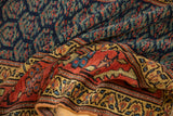 Antique Kurdish runner folded, highlighting geometric boteh and wide, nuanced aubergine border.