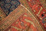 Wide gold border, terra cotta field, and navy blue patterns on an antique Kurdish runner.