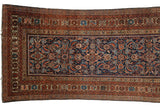 Hallmark Fereghan green border framing the intricate rust and blue Herati design on a navy field.