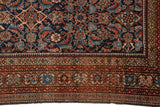 Signature green Fereghan border contrasting with the dense, navy blue Herati patterned field.