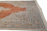 Angled view of the vintage Tabriz carpet's corner, showing the ivory spandrels and floral border.