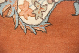 Close-up of the vintage Tabriz carpet's plush pile, showing blue and sand arabesques on a rust field.