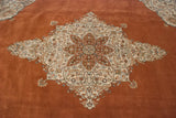 Elaborate starburst medallion with scrolling vinery on a dusty rust wool pile.