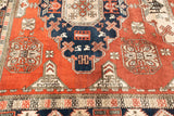 Geometric relief patterns of a vintage Persian Meshkin rug in copper, dark navy, and ivory.