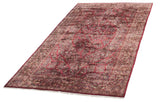 Angled full-length view of a vintage Sarouk carpet with a rich ruby red and floral field.
