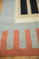 Hand-woven Kilim runner detail showing abstract stepped blocks in terra cotta, black, and sage.