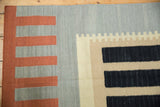 Terra cotta, silver, and black geometric blocks with stepped beige patterns on a flat-woven Kilim.