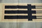 Abstract modern Kilim runner showing black and beige stepped geometric pattern.