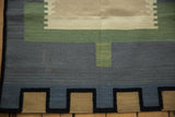 Vintage Contemporary Kilim rug featuring charcoal, sage, and tan geometric block patterns.