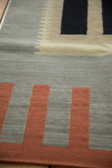 Vintage Contemporary Kilim rug with abstract terra cotta, sage, and charcoal geometric blocks.
