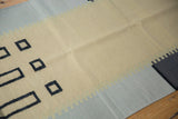 Abstract modern Kilim runner with light beige, gray, and dark geometric shapes.