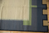 Detail of architectural geometric blocks and stepped pattern in beige, charcoal, and sage green.