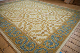 Vintage Spanish Alcaraz carpet: corner view of scrolling serpent tendrils and blue dragon border.