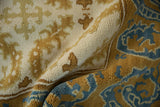 Detail of vintage Spanish Alcaraz carpet with blue and saffron yellow dragon-inspired motifs.