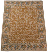 Angled perspective of a vintage Spanish carpet's scrolling gold vinery and multi-color floral border.