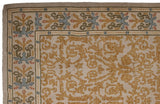 Corner view showing the germinating plant motif border of a vintage Spanish Arts and Crafts rug.